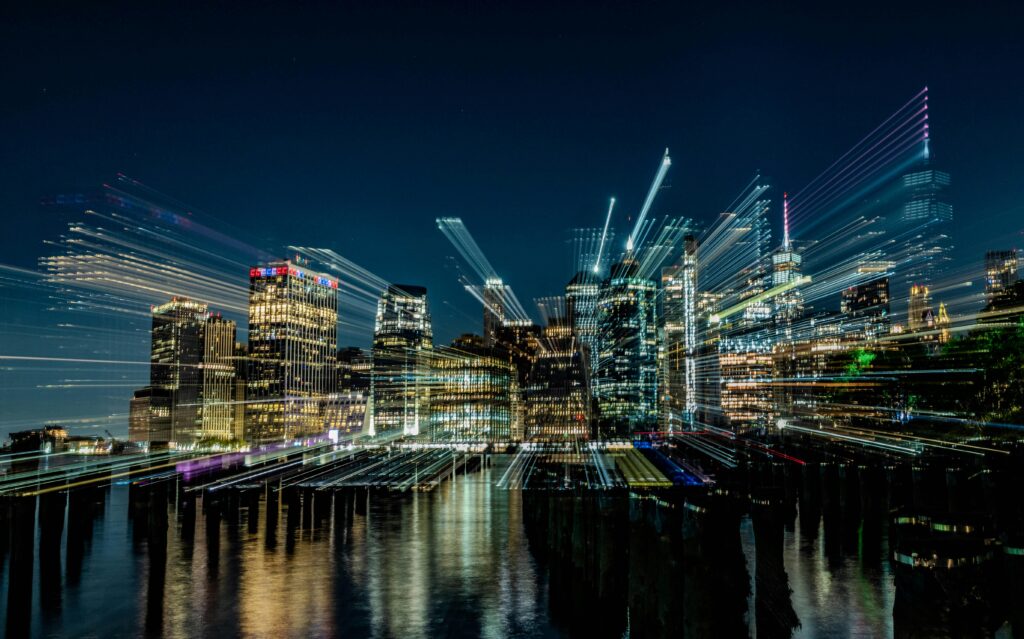 Abstract light streaks and data paths over a city skyline at night representing algorithmic real estate valuation software.